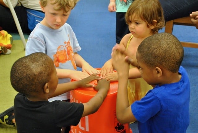 children drumming on a bucket