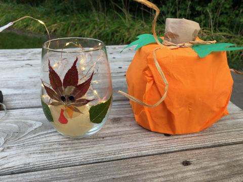 Photo of crafted pumpkin and turkey on glass jar with fairy lights inside