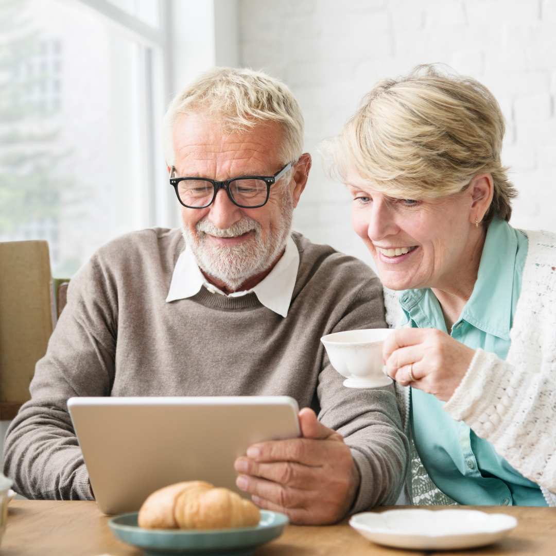 A senior couple looking at an iPad together.